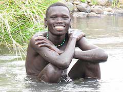 Jeune homme Surma se baignant dans un cours d’eau proche du village.