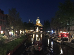 En soirée,  l'Oudezijds Voorburgwal, souvent appelé le canal Oz Voorburgwal. La basilique de Saint-Nicolas est visible à l'arrière-plan.